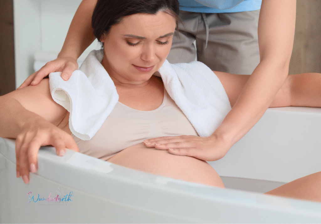 A mother relaxing in a birthing tub during labor, showcasing the benefits of water births.