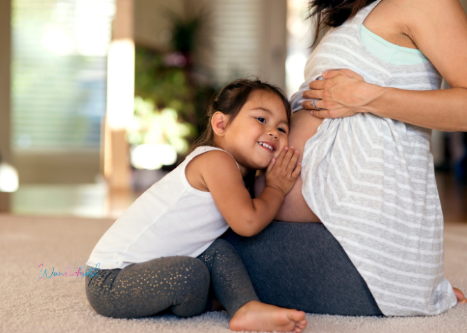 Young child listens for baby in mommy's pregnant belly, prepping in anticipation for baby's arrival.