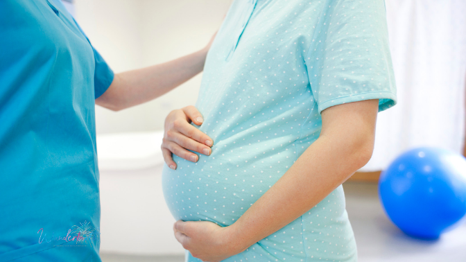 A close-up of a birthing mother in a hospital room setup with a nurse holding her shoulder.