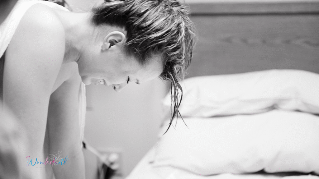 A pregnant woman showing various signs of active labor in a birthing center.